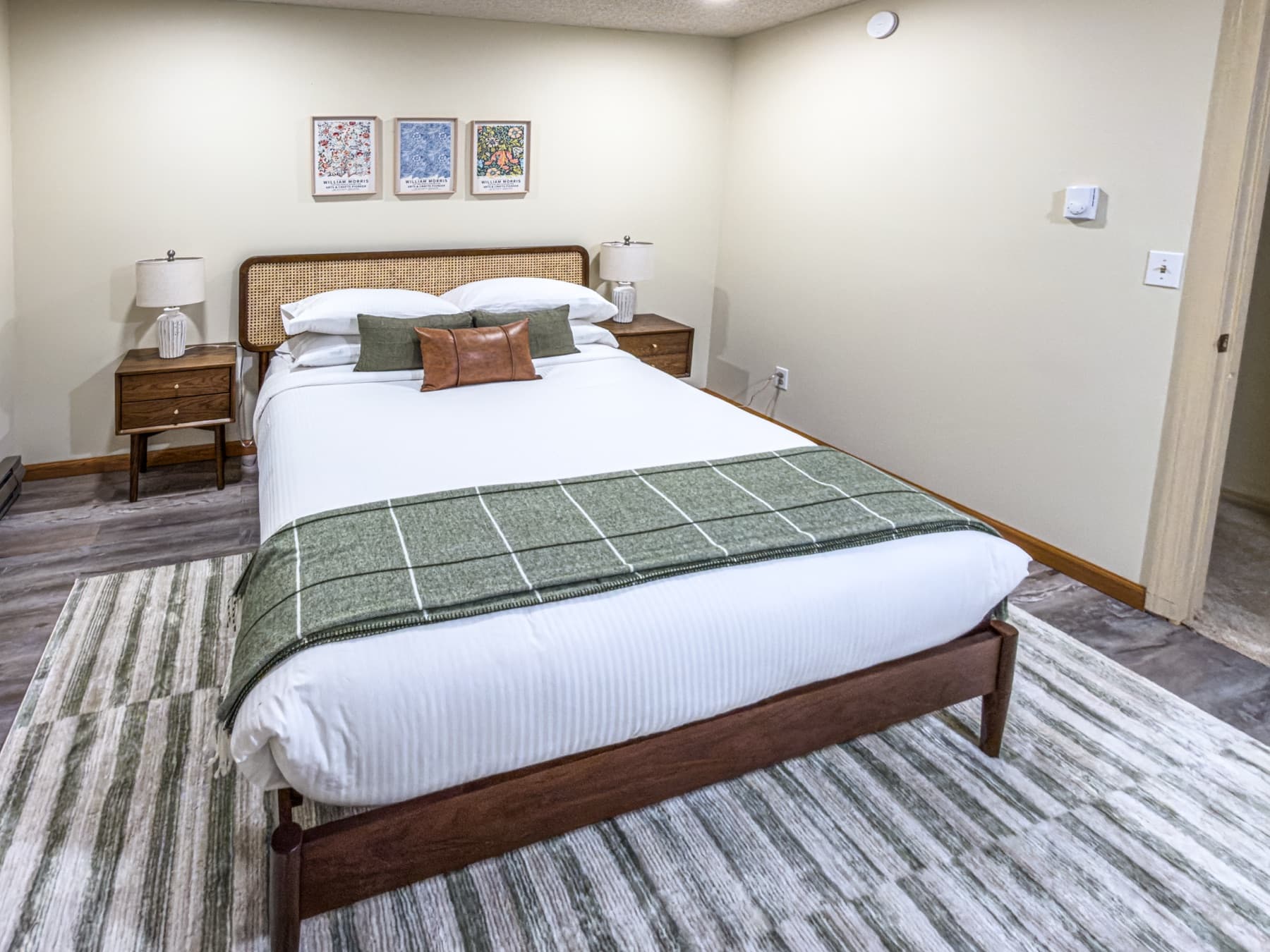 Upstairs queen bedroom — warm tones, forest views